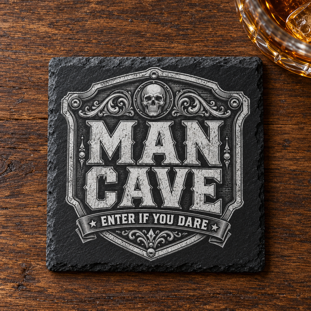 Glasunderlägg i skiffer med graverad dödskalle, dekorativ sköld och texten Man Cave – Enter If You Dare.