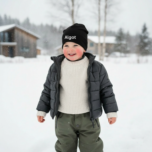 Barn med svart Edda-mössa med namnet Algot