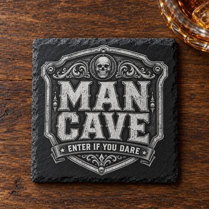 Glasunderlägg i skiffer med graverad dödskalle, dekorativ sköld och texten Man Cave – Enter If You Dare.