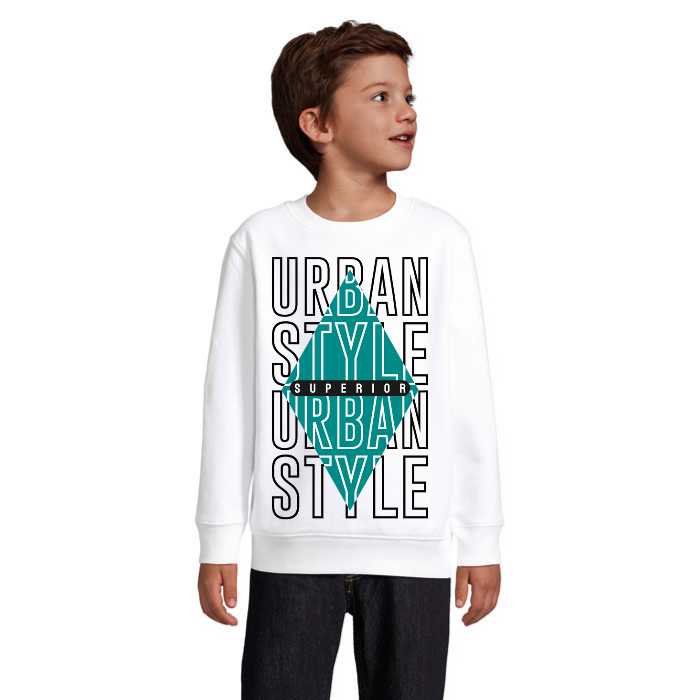 Barn i vit sweatshirt med stora Urban Style-konturbokstäver, turkos romb och ett svart band med vit Superior-text.