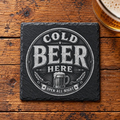 Glasunderlägg i skiffer med graverad ölsejdel och texten Cold Beer Here – Open All Night i en rund vintageram.