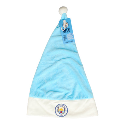 En ljusblå tomteluva med vit kant och boll, prydd med Manchester City FC:s klubbmärke.