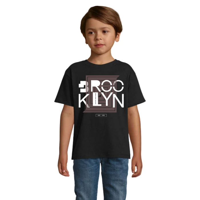Barn i svart T-shirt med stora vita Brooklyn-bokstäver över två rader, geometriska ramar i bruna toner och liten NYC USA-text.