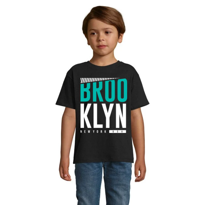 Barn i beige T-shirt med Brooklyn-tryck i stora turkosa och vita bokstäver, randig detalj upptill och texten New York USA undertill.
