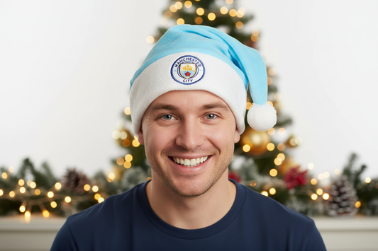 En ljusblå tomteluva med vit kant och boll, prydd med Manchester City FC:s klubbmärke.